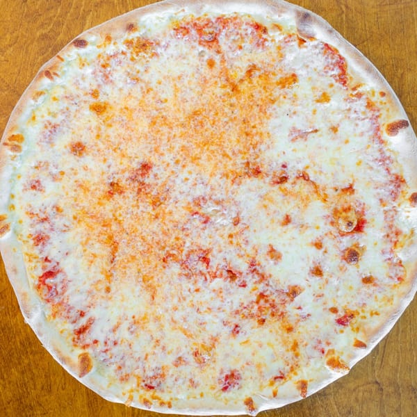 A whole, round Catania's Pizza cheese pizza with a golden crust on a wooden surface.